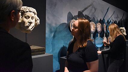 Zwei Frauen betrachten in Ausstellung eine Steinbüste von Wilhelm dem Eroberer