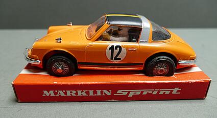 Oranges Rennwagenmodell mit der Nummer 12 an der Seite, es steht auf einem Karton mit der Aufschrift "Märklin Sprint"