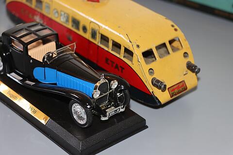 blau-schwarzes Automodell Bugatti Coupe und gelb-roter Bugatti Triebwagen