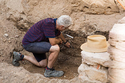 Ein Archäologe arbeitet auf einer Grabungsstelle