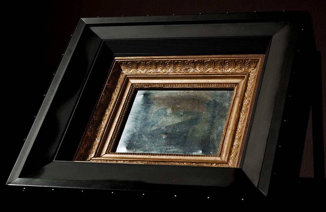 2012 war die erste Fotografie der Welt zu Gast bei uns in den Reiss-Engelhorn-Museen Eine Zinnplatte, auf der man schwach Gebäude erkennen kann und die sich in einem verzierten Rahmen befindet, wird in leichter Schräglage ausgestellt.