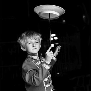 ein Junge lässt im Zirkus einen Teller rotieren