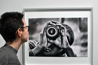 Besucherin betrachtet eine schwarz-weiß-Fotografie