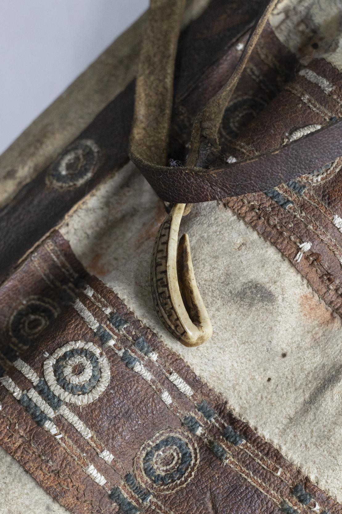 Detail eines Pfeilköchers der Tschuktschen Detail eines Pfeilköchers aus Leder in weiß und Braun. Auf den braunen streifen gibt es runde Ornamente.