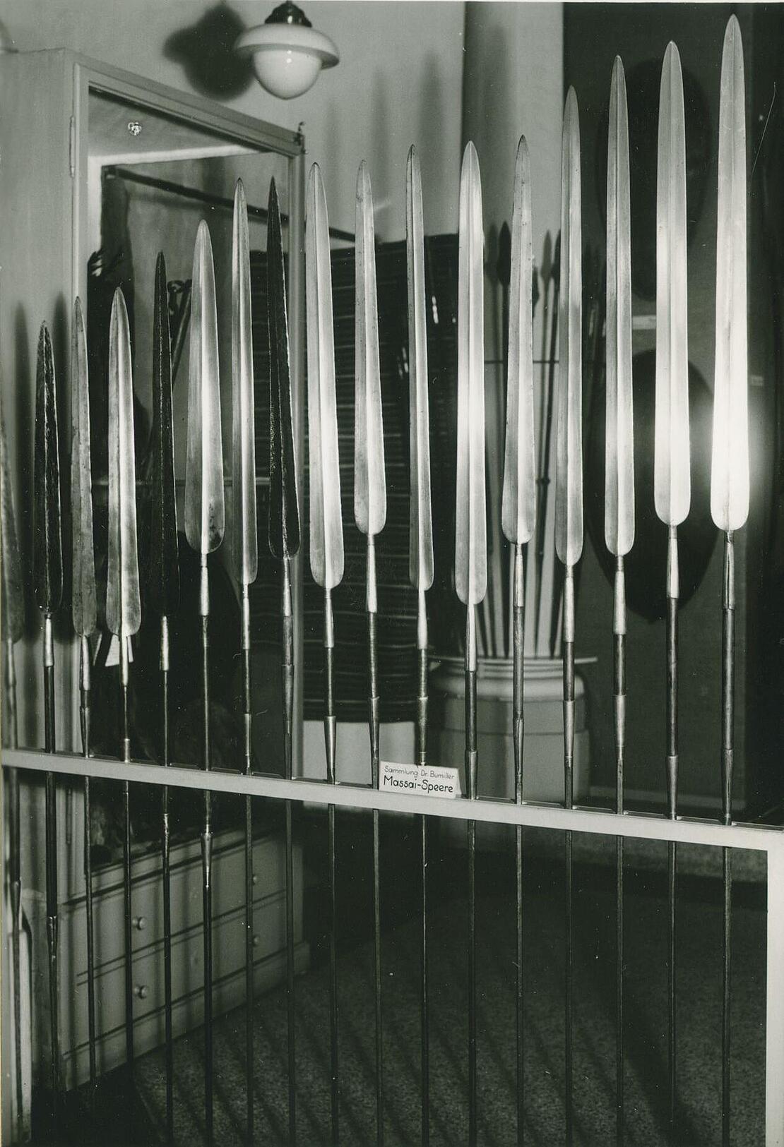 Schwarz-weiß-Bild zeigt aufgereihte Speere in einer Ausstellung