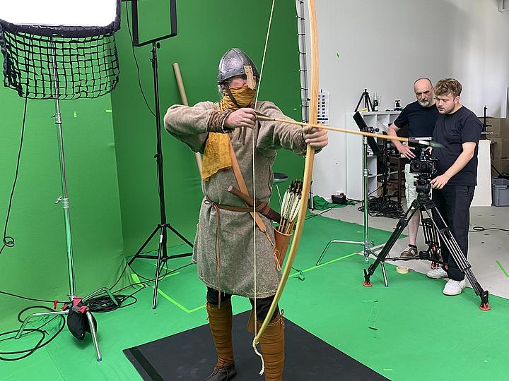 Filmszene mit mittelalterlichem Bogenschützen vor "Green Screen"