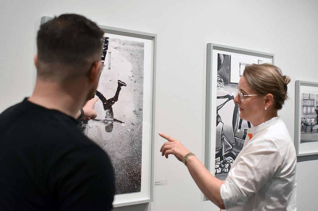 Zwei Menschen betrachten eine Schwarz-Weiß-Fotografie