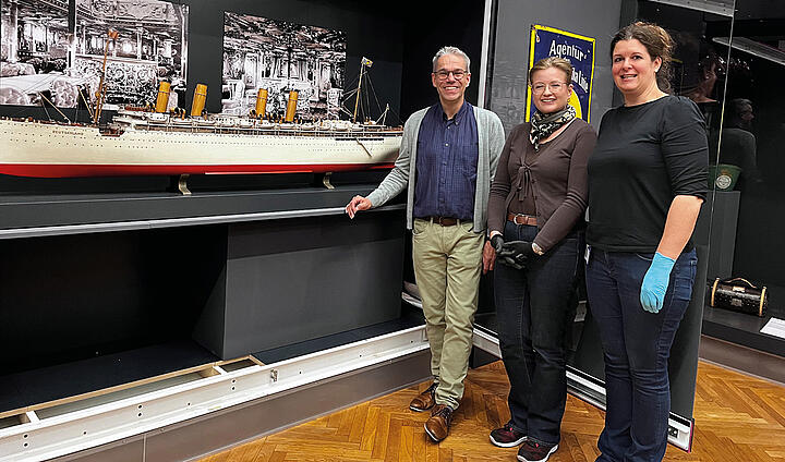 Schiffsmodell in Ausstellung mit Kurator Andreas Krock und die Restauratorinnen Gisela Gulbins und Isabel Luft