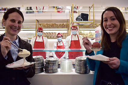Zwei Frauen probieren in einer Eisdiele Eis.