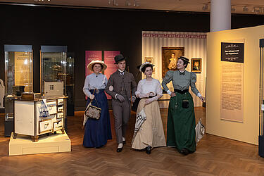 Besuchergruppe im Kostüm spaziert durch die Ausstellungsräume