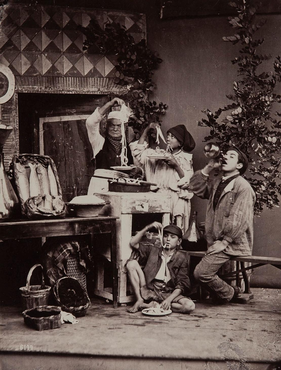 Historische Fotografie auf der mehrere Personen Nudeln essen