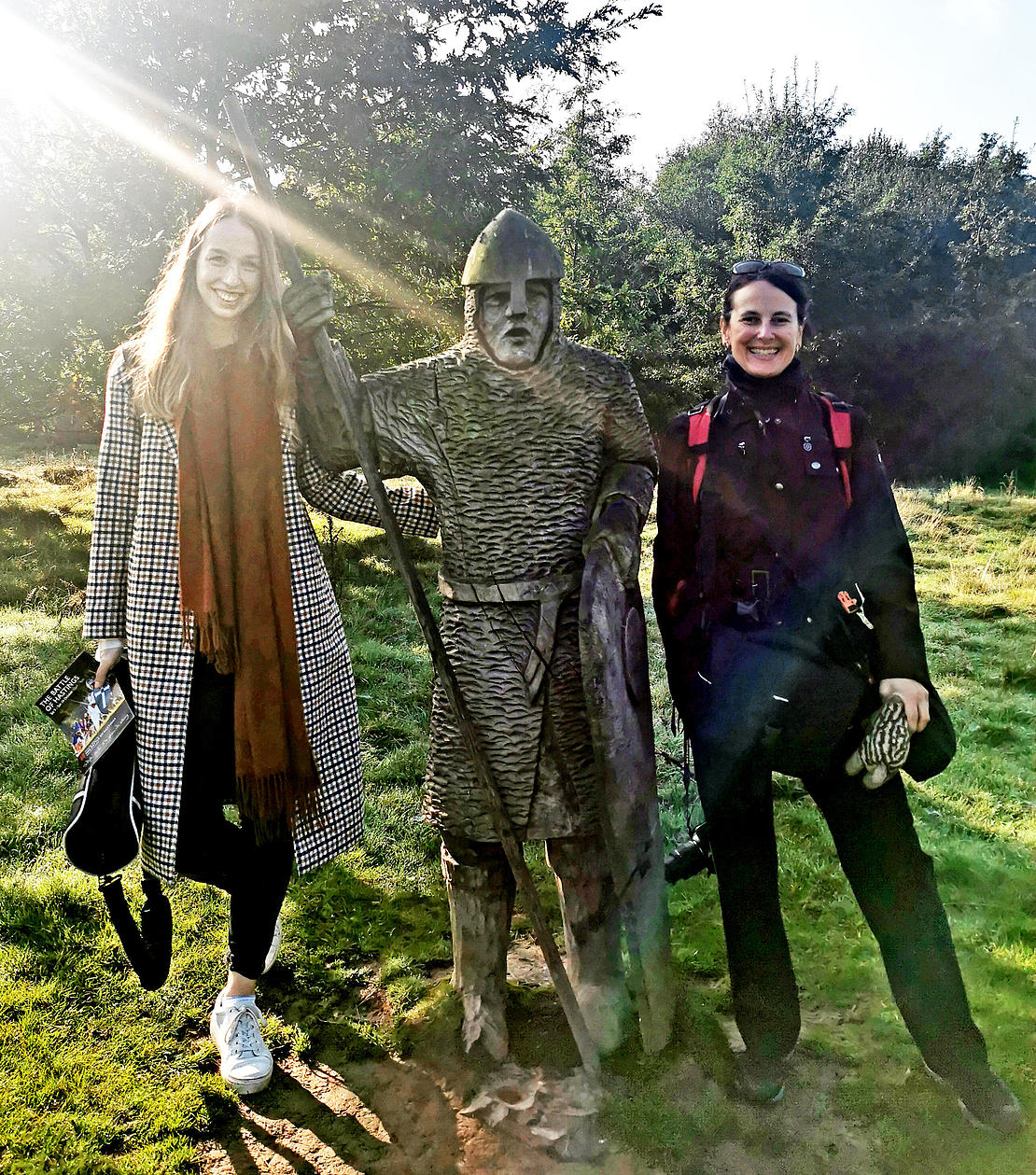 zwei Frauen, in ihrer Mitte die lebensgroße Figur eines mittelalterlichen Kriegers