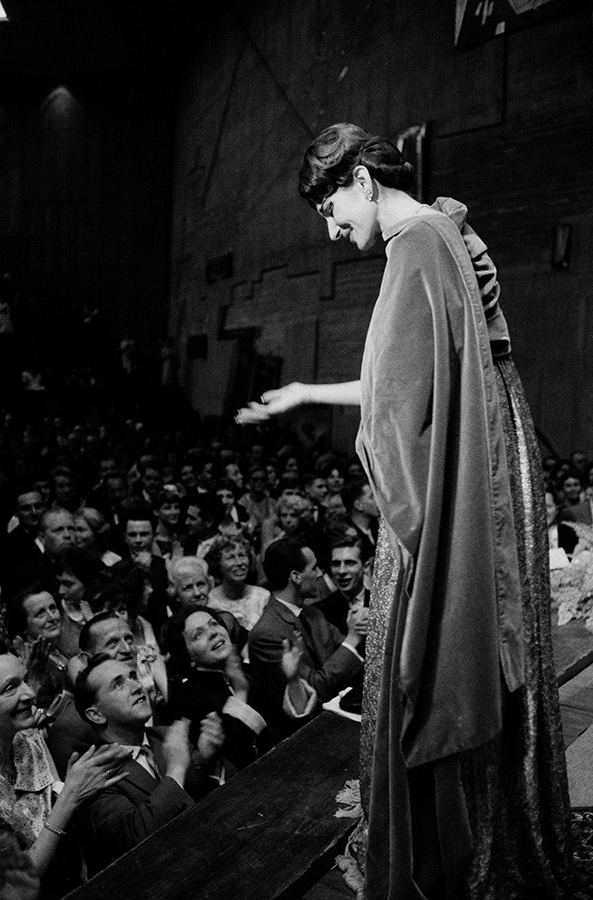 Schwarz-weiß-Foto zeigt Sängerin Maria Callas auf der Bühne, im Zuschauerraum unter ihr jubelnde Menschen