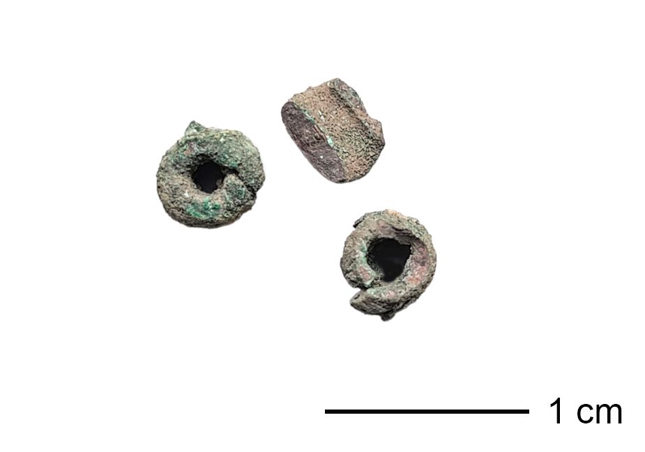 Drei abgenutzte Perlen aus Bronze